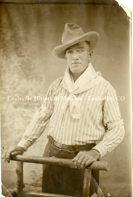 Man in white shirt, neck kerchief, and cowboy hat
