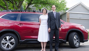 Modern photo of a man and woman standing in front of a car.