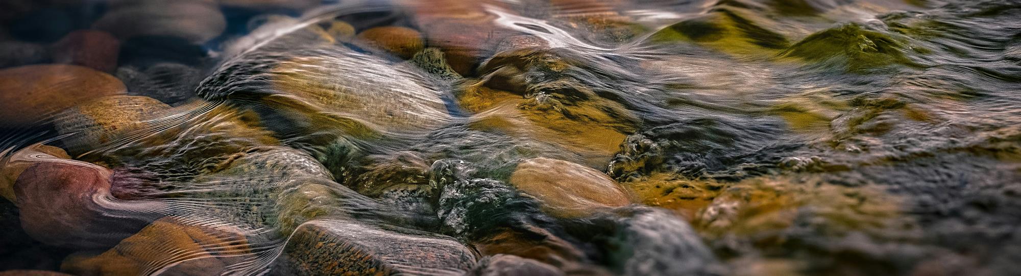 Close-up of water running over pebbles.